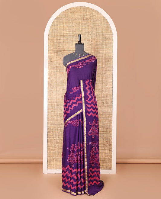 Violet wax batik-style zig-zag printed pure cotton saree, gold zari piping border, human figurines batik printed pallu, and a matching blouse