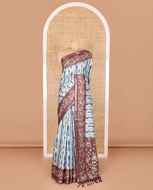 Blue shibori printed katan silk saree, contrast border, and pallu of kalamkari floral vine and peacock print, and a contrast leaf printed blouse