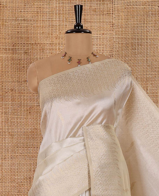 Cream Semi Tussar Saree Enriched with Zari Floral Buttas, Gleaming Zari Design Border, Majestically Detailed Pallu in Zari, and Paired with a Matching Blouse
