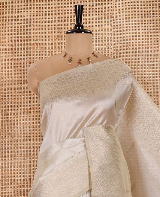 Cream Semi Tussar Saree Enriched with Zari Floral Buttas, Gleaming Zari Design Border, Majestically Detailed Pallu in Zari, and Paired with a Matching Blouse