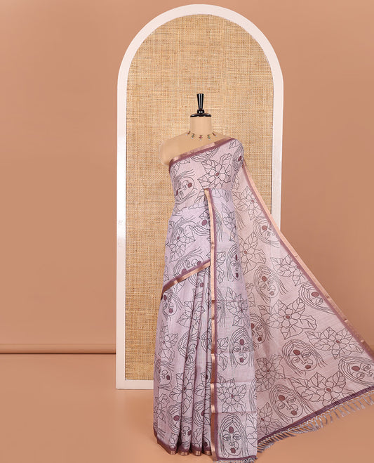 Light Mauve Linen Saree Creatively Printed with Girl Face and Floral Motifs All Over Its Body, Subtly Sparkled with Piping Zari Border, Pallu Mirrors the Same Body Print, and Paired with a Contrast Blouse