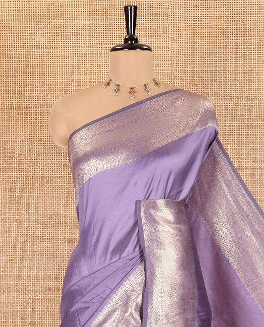 Lavender Plain Semi-Soft Silk Saree, Decked Up with Traditional Zari Designs Woven Border, Grandly Woven Pallu Steeped with Chakram Designs, and Paired with a Matching Blouse