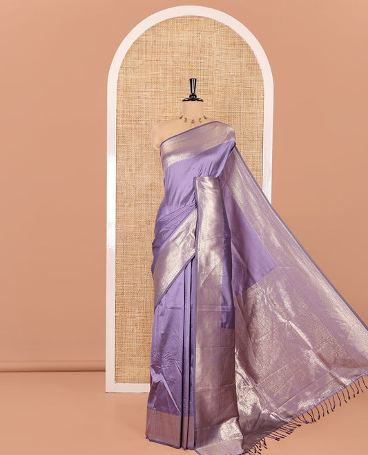 Lavender Plain Semi-Soft Silk Saree, Decked Up with Traditional Zari Designs Woven Border, Grandly Woven Pallu Steeped with Chakram Designs, and Paired with a Matching Blouse