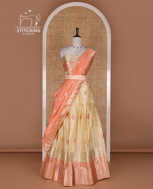 Cream taffeta silk half saree, meena buttas skirt, contrast peach traditional zari border, matching blouse, and zari woven dhavani
