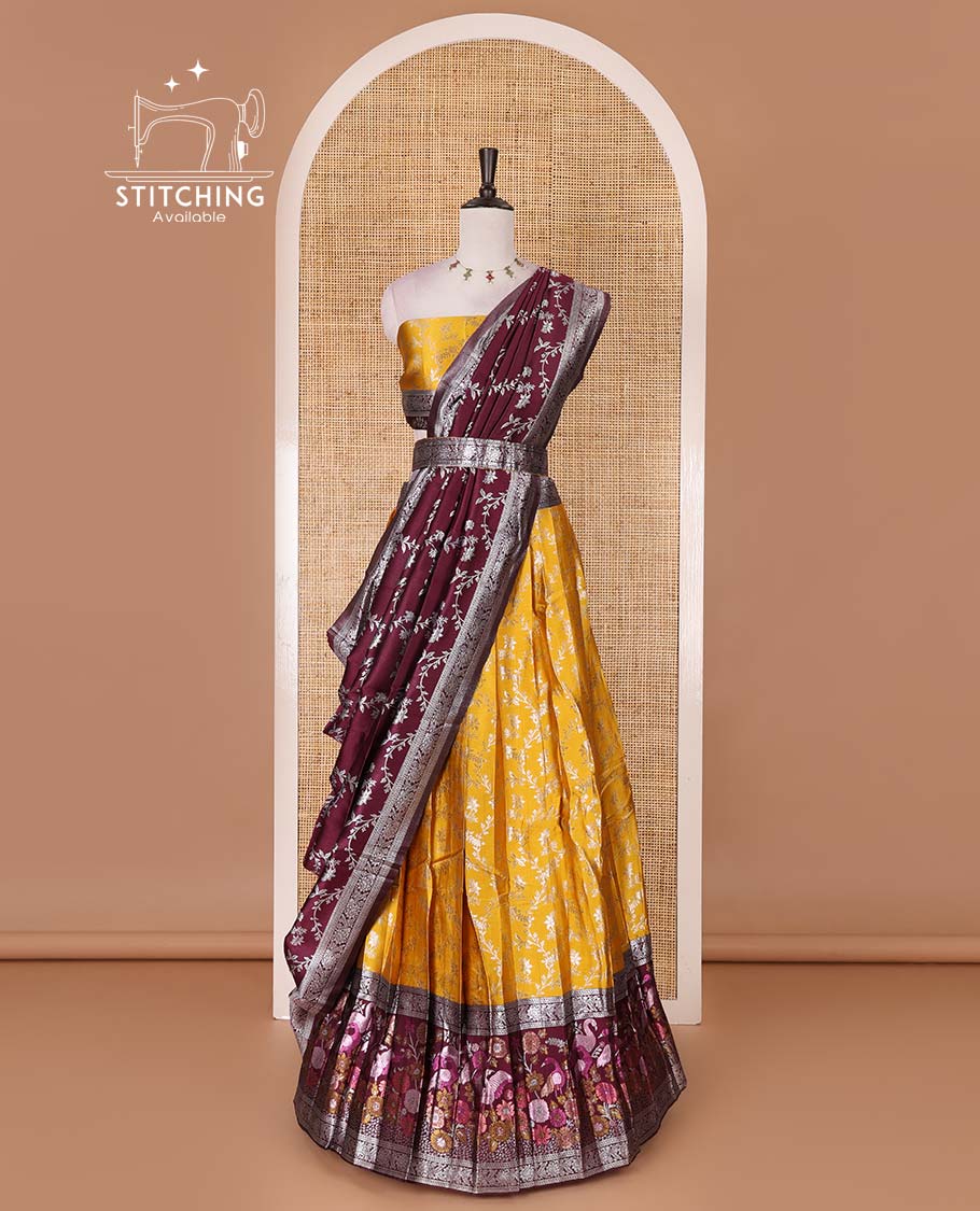 Haldi yellow taffeta silk half saree, floral jaal jacquard skirt, contrast wine zari meenakari style bird border, matching blouse, and floral jaal dhavani