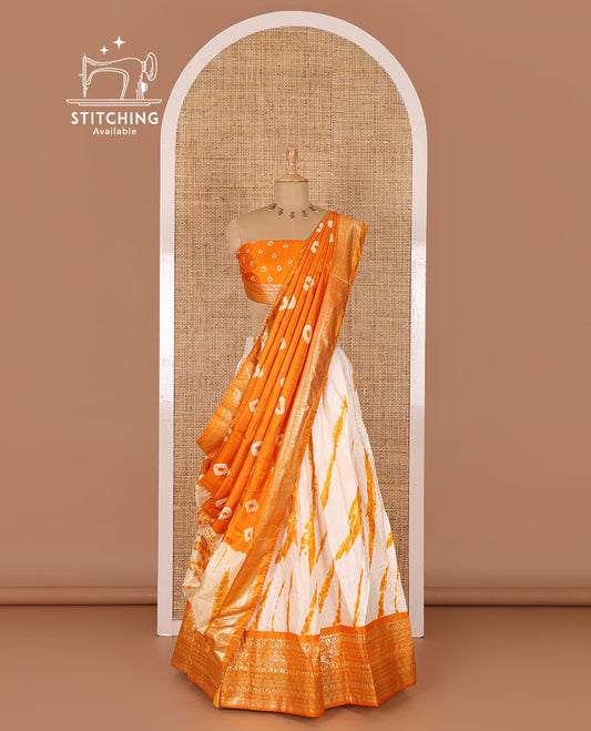 Cream and yellow semi-tussar half-saree, shibori printed with contrast geometric patterned bordered skirt, bandhani printed blouse, and bandhani printed dhavani