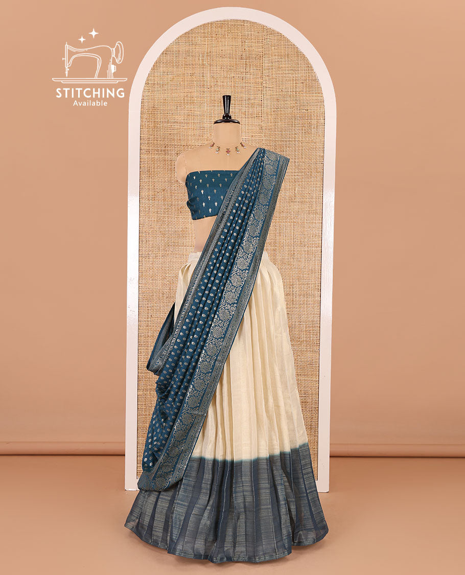 Cream-peacock blue Vichitra half-saree, plain and contrast bordered skirt, contrast leaf buttas blouse, dhavani of buttas and floral creeper designs