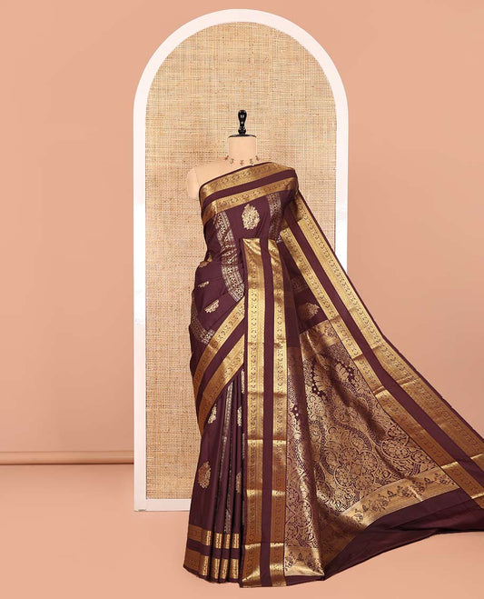 Brown Kanchipuram budget silk saree elevated with zari designs all over its body, complemented by rettai pettu traditional zari design border, Mughal-style intricately woven pallu, and paired with a Matching blouse