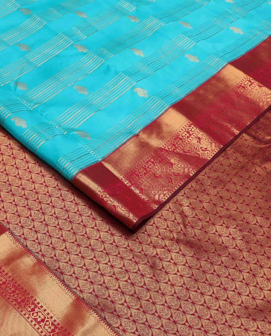 Blue zari buttas and striped Vasundhara silk mix saree, contrast border of thilakam mokku, mayil kann, paisa and paithani-style zari designs, and thilakam steeped pallu
