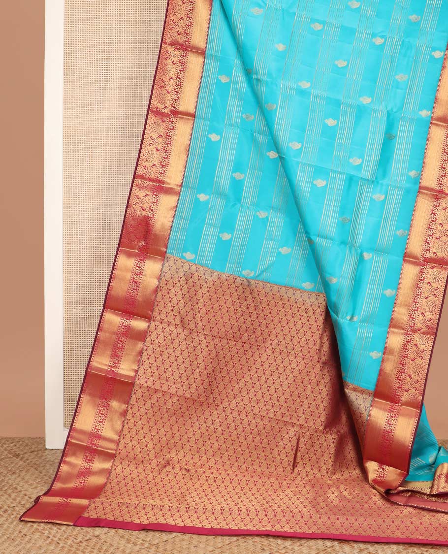 Blue zari buttas and striped Vasundhara silk mix saree, contrast border of thilakam mokku, mayil kann, paisa and paithani-style zari designs, and thilakam steeped pallu