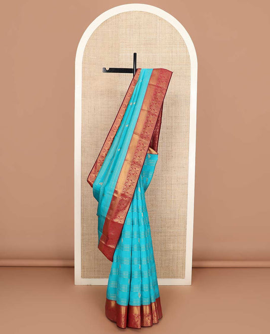 Blue zari buttas and striped Vasundhara silk mix saree, contrast border of thilakam mokku, mayil kann, paisa and paithani-style zari designs, and thilakam steeped pallu