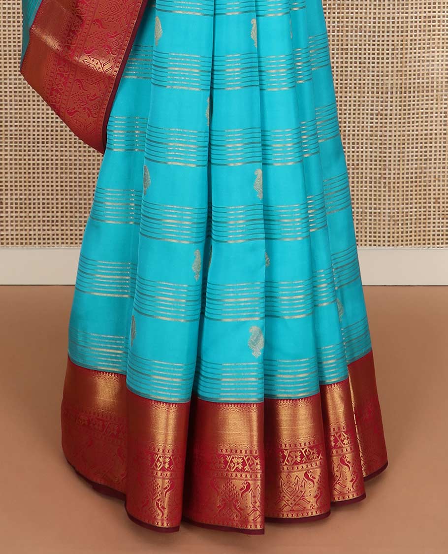 Blue zari buttas and striped Vasundhara silk mix saree, contrast border of thilakam mokku, mayil kann, paisa and paithani-style zari designs, and thilakam steeped pallu