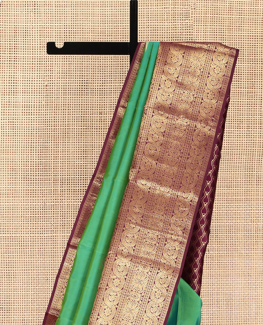 Sea Green Vasundhara Silk Saree, Accentuated with Zari Buttas All Over Its Body, Complemented by Contrast Border of Ara Bogudi, Banaras, Jada Nagam and Dhavana Kodi Designs, Pallu of Intricate Designs, and Paired with a Contrast Blouse