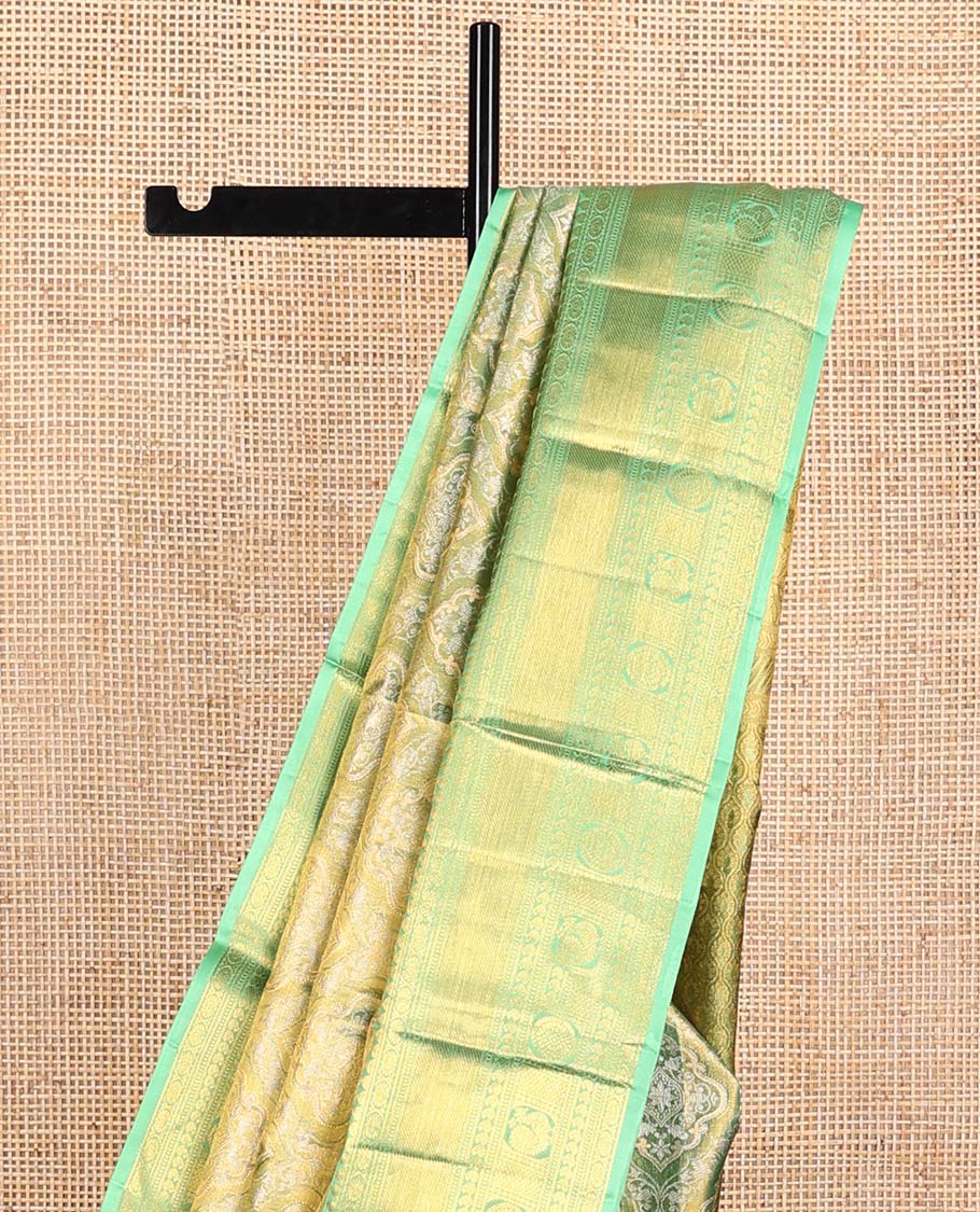Green Kanchipuram Tissue Silk Saree, Elevated with Jacquard Design on Its Body, Complemented by a Contrast Border of Rekku, Kamalam, Banaras, Muthu, Manga, Mayil, and Mayil Kann Designs, Grand Ogee Pallu, and Paired with a Contrast Blouse