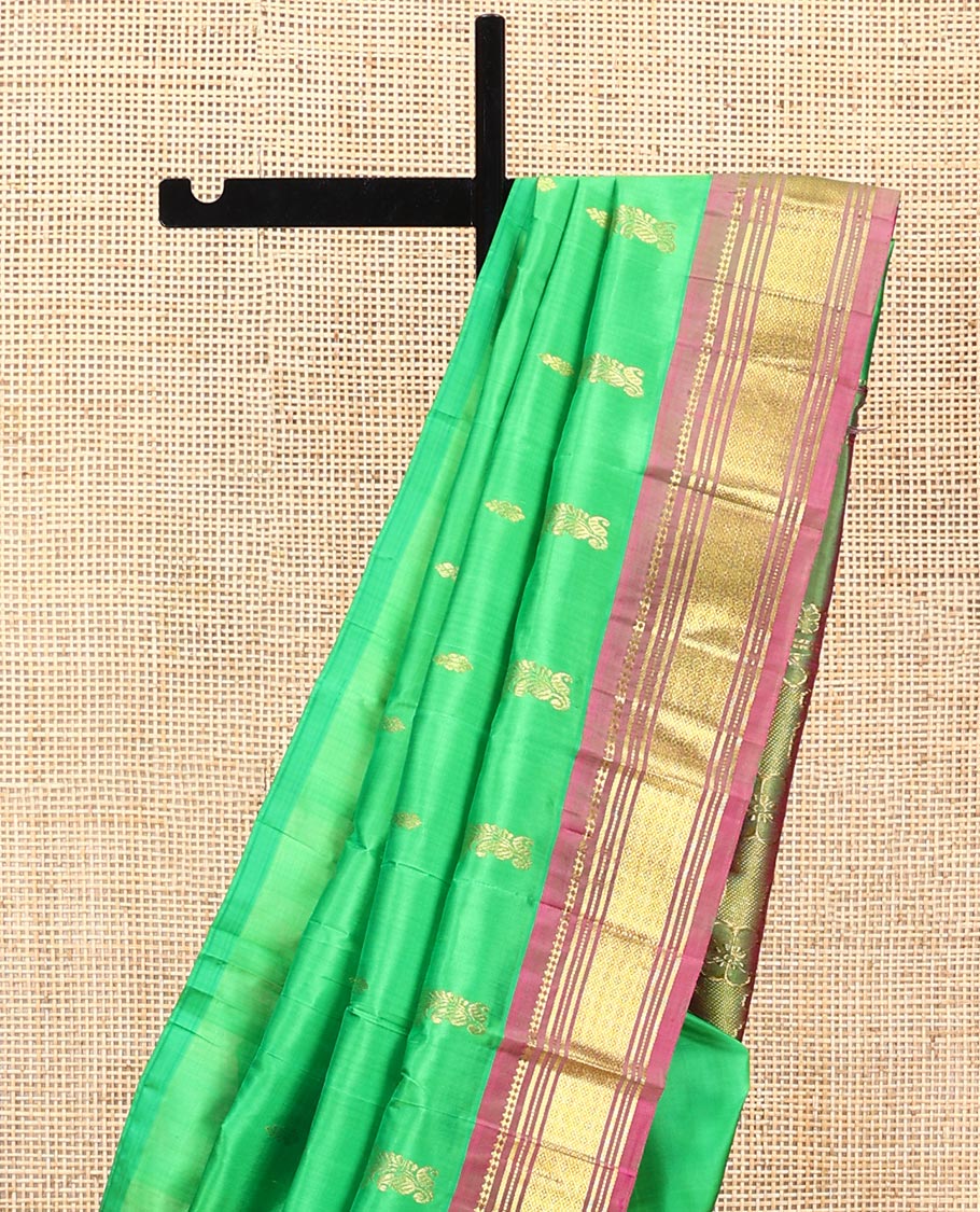 Green Kanchipuram Silk Saree, Adorned with Zari Buttas All Over Its Body, Complemented by a Contrast One-Sided Border of Panner Sombu, Banaras, Muthu, and Jaal Designs, Pallu of Floral Paisleys, and Comes Without a Blouse