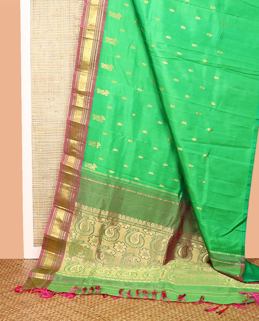 Green Kanchipuram Silk Saree, Adorned with Zari Buttas All Over Its Body, Complemented by a Contrast One-Sided Border of Panner Sombu, Banaras, Muthu, and Jaal Designs, Pallu of Floral Paisleys, and Comes Without a Blouse