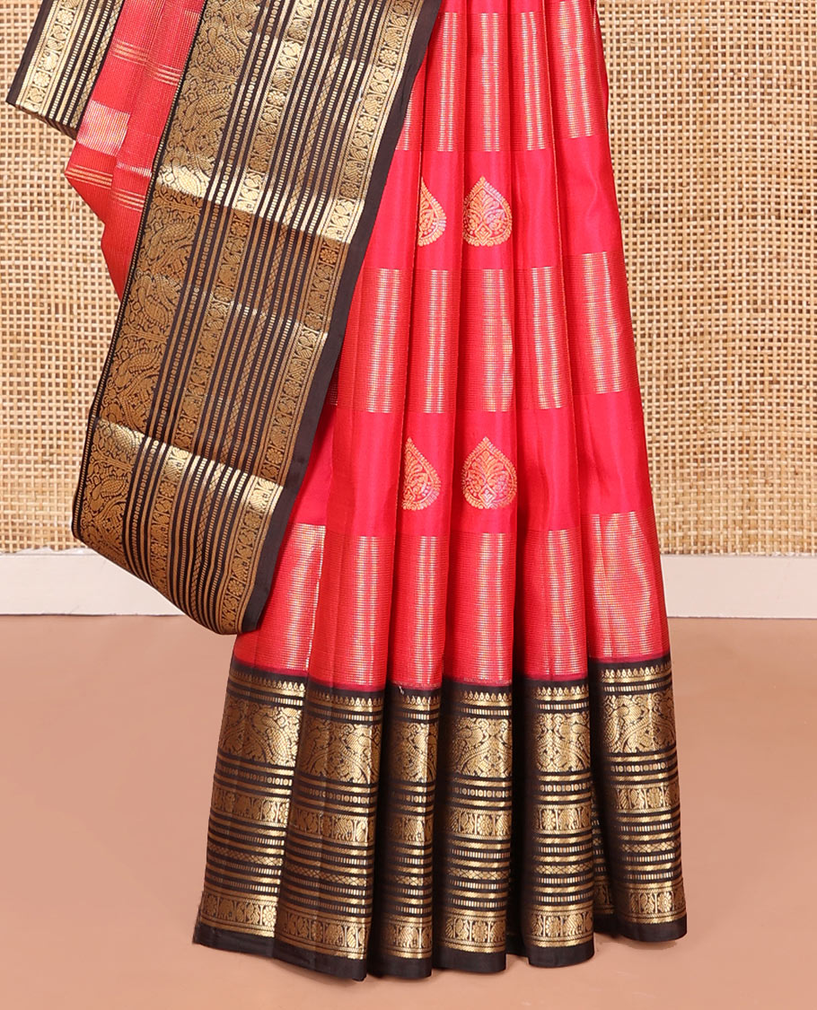 Red Vasundhara Silk Saree, Accentuated with Zari Buttas and Zari Stripes All Over Its Body, Complemented by a Contrast Border of Thilakam, Banaras, Muthu, Yaanai, Manga, and Mayil Designs, Zari Elevated Jaal Pallu, and Paired with a Contrast Blouse