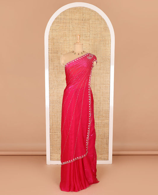 Rani pink micro-stone work fendy chiffon saree with paisley stone work on its shoulder, a scallop stone work border, a butterfly style pallu, and a matching stone work blouse