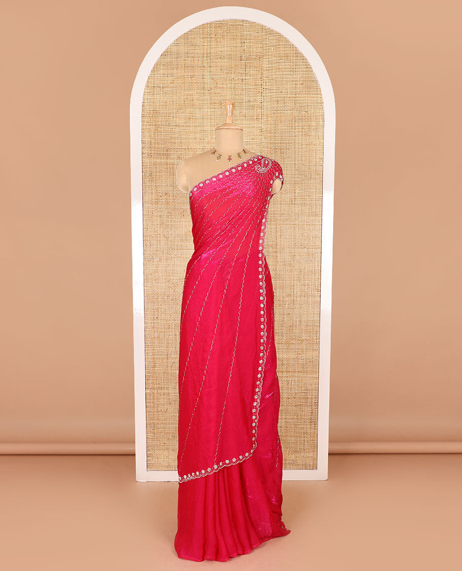 Rani pink micro-stone work fendy chiffon saree with paisley stone work on its shoulder, a scallop stone work border, a butterfly style pallu, and a matching stone work blouse