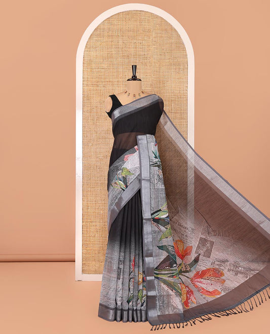 White and Black Linen Cotton Saree, Creatively Designed with Tropical Floral, and Newspaper-Texture Printed on Its Body, Complemented by a Silver Tissue Border, a Self-Printed Pallu, and Paired with a Matching Blouse