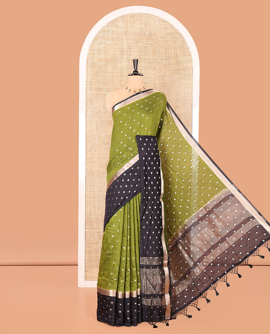 Olive Green Assam Silk Saree, Charmingly Accented with Zari Buttas on Its Body, Complemented by Contrast Border Steeped with Zari Buttas, Pallu Steeped with Gleaming Zari Stripes and Buttas, and Paired with a Contrast Blouse