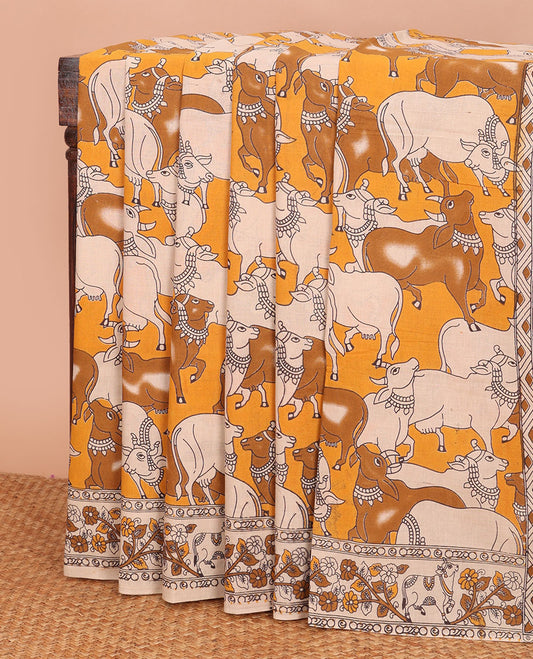 Yellow Pichwai cow machine-printed kalamkari cotton saree, floral printed border & pallu of Pichwai cow & Radha Krishnan motif print