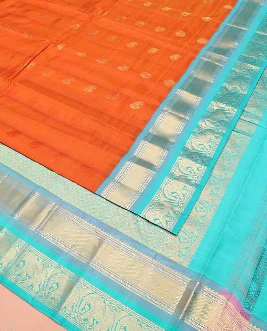 Orange Vasundhara Silk Saree Embellished with Yaanai and Poun Buttas All Over Its Body, Complemented by Zari Border of Neli, Mayil Kann, and Yaanai Designs, a Grand Pallu of Jaal Designs, and Paired with a Contrast Blouse
