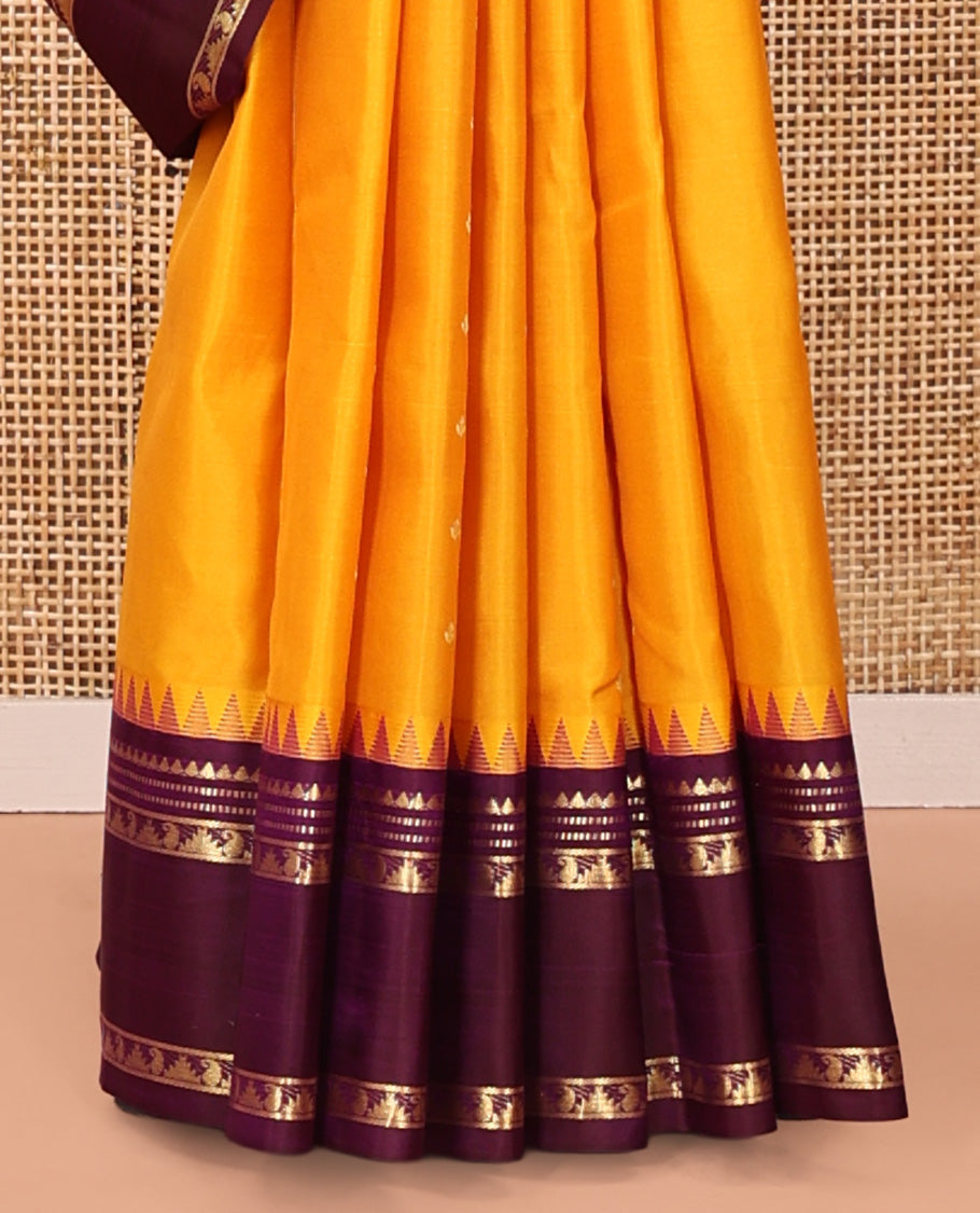 Yellow Vasundhara Silk Saree, Subtly Sparkled with Zari Buttas All Over Its Body, Complemented by a Contrast Rettai Pettu Temple Border of Rekku, Muthu, Manga, and Thazampoo Rekku Designs, Grand Pallu, and Paired with a Contrast Blouse