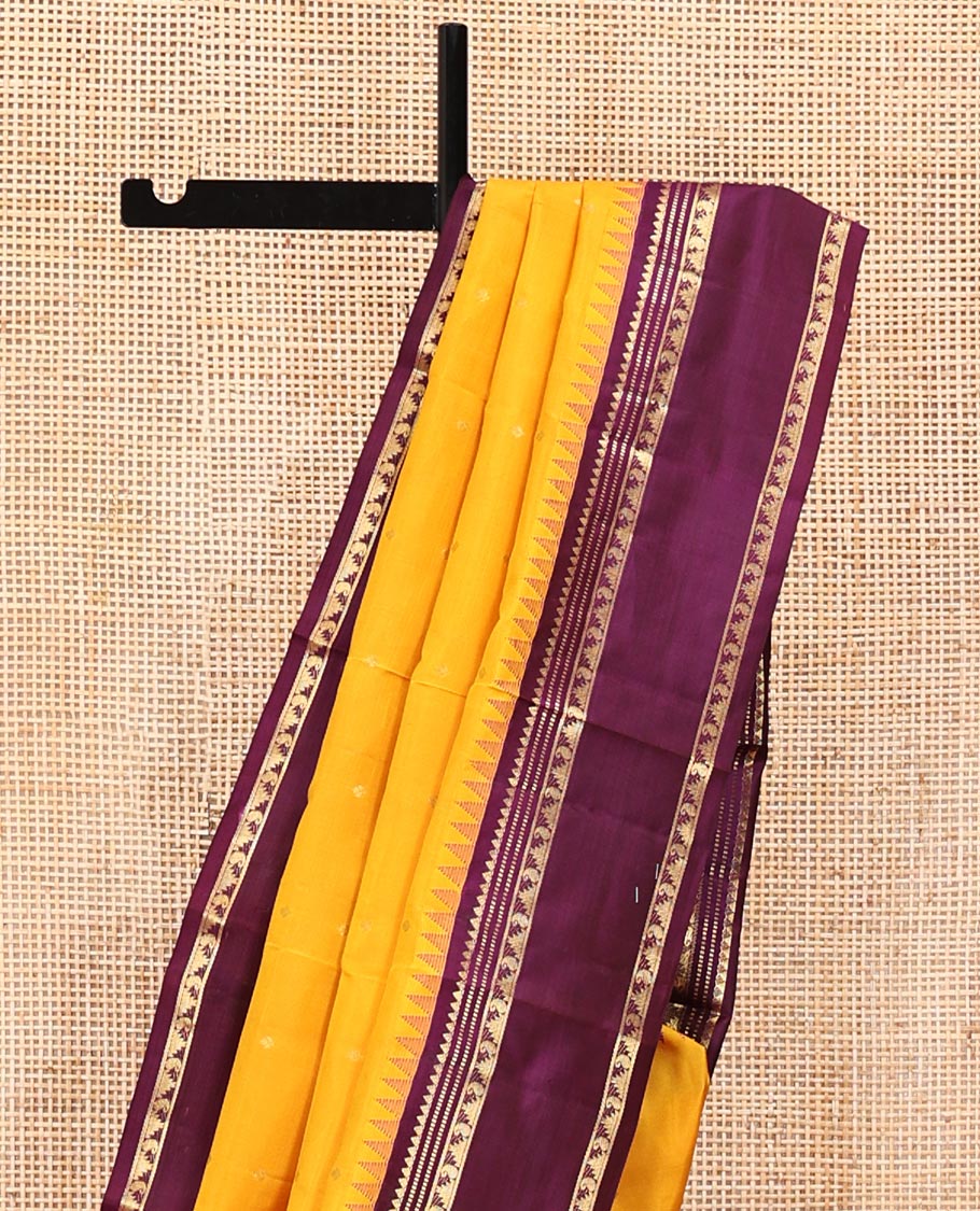 Yellow Vasundhara Silk Saree, Subtly Sparkled with Zari Buttas All Over Its Body, Complemented by a Contrast Rettai Pettu Temple Border of Rekku, Muthu, Manga, and Thazampoo Rekku Designs, Grand Pallu, and Paired with a Contrast Blouse