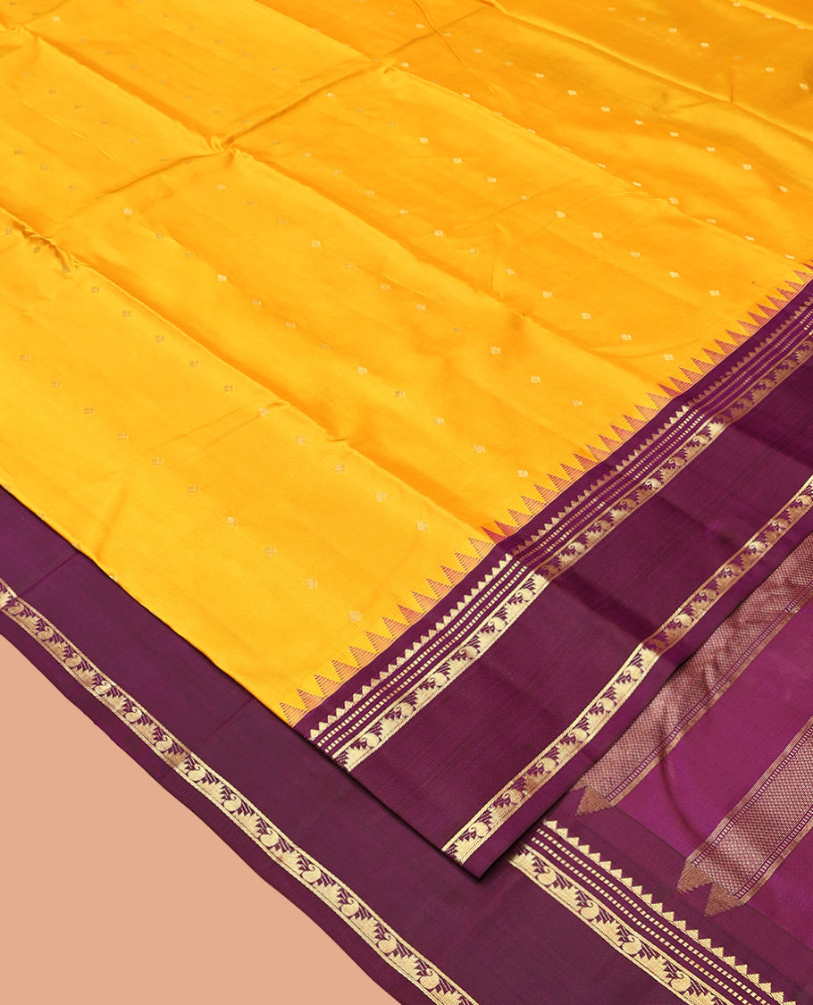Yellow Vasundhara Silk Saree, Subtly Sparkled with Zari Buttas All Over Its Body, Complemented by a Contrast Rettai Pettu Temple Border of Rekku, Muthu, Manga, and Thazampoo Rekku Designs, Grand Pallu, and Paired with a Contrast Blouse