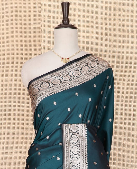 Blue Semi-Banaras Satin Saree Subtly Sparkled with Zari Buttas, Self-Border Adorned with Floral Creeper Designs, Pallu Artfully Detailed with Ogee Designs, and Paired with a Matching Blouse