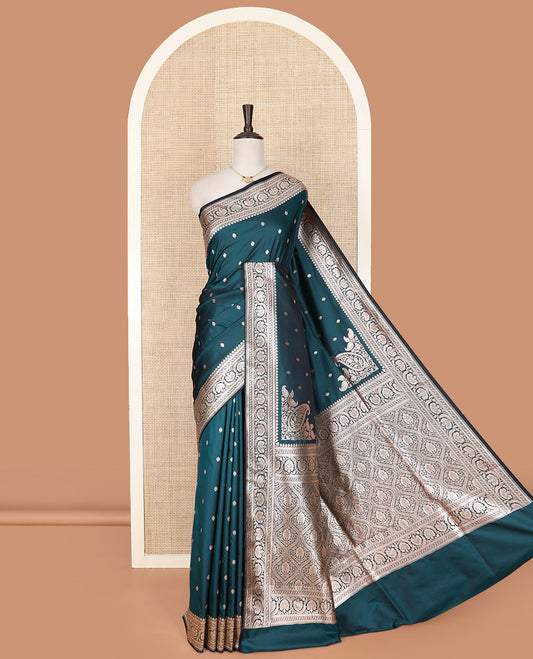 Blue Semi-Banaras Satin Saree Subtly Sparkled with Zari Buttas, Self-Border Adorned with Floral Creeper Designs, Pallu Artfully Detailed with Ogee Designs, and Paired with a Matching Blouse