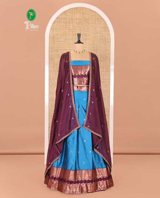 Blue-Purple Semi-Banarasi Half-Saree Mesmerized with Zari Buttas on Its Skirt, Complemented by a Contrast Traditional Zari Temple Rettai Pettu Border, Paired with a Matching Blouse, and a Satin Georgette Embroidered Scallop Dhavani