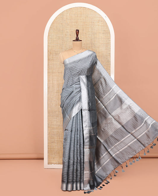 Grey Banana Pith Saree, Subtly Sparkled with Buttas All Over Its Body, Highlighted by Zari Temple Border, Gleaming Pallu Steeped with Stripes, and Paired with a Matching Blouse