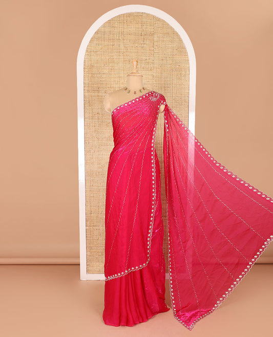 Rani pink micro-stone work fendy chiffon saree with paisley stone work on its shoulder, a scallop stone work border, a butterfly style pallu, and a matching stone work blouse