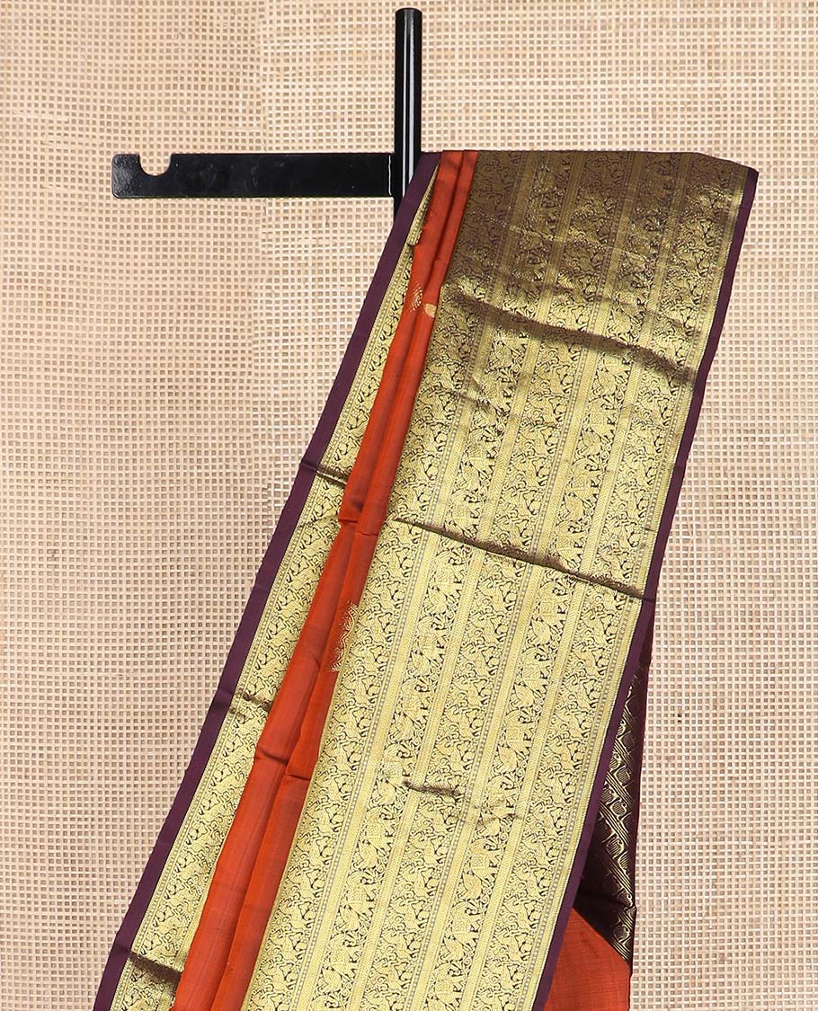 Orange manga buttas Kanchipuram silk saree, contrast border of thilakam mokku, kathir, kuthirai, and yaanai designs, and pallu steeped with manga motifs