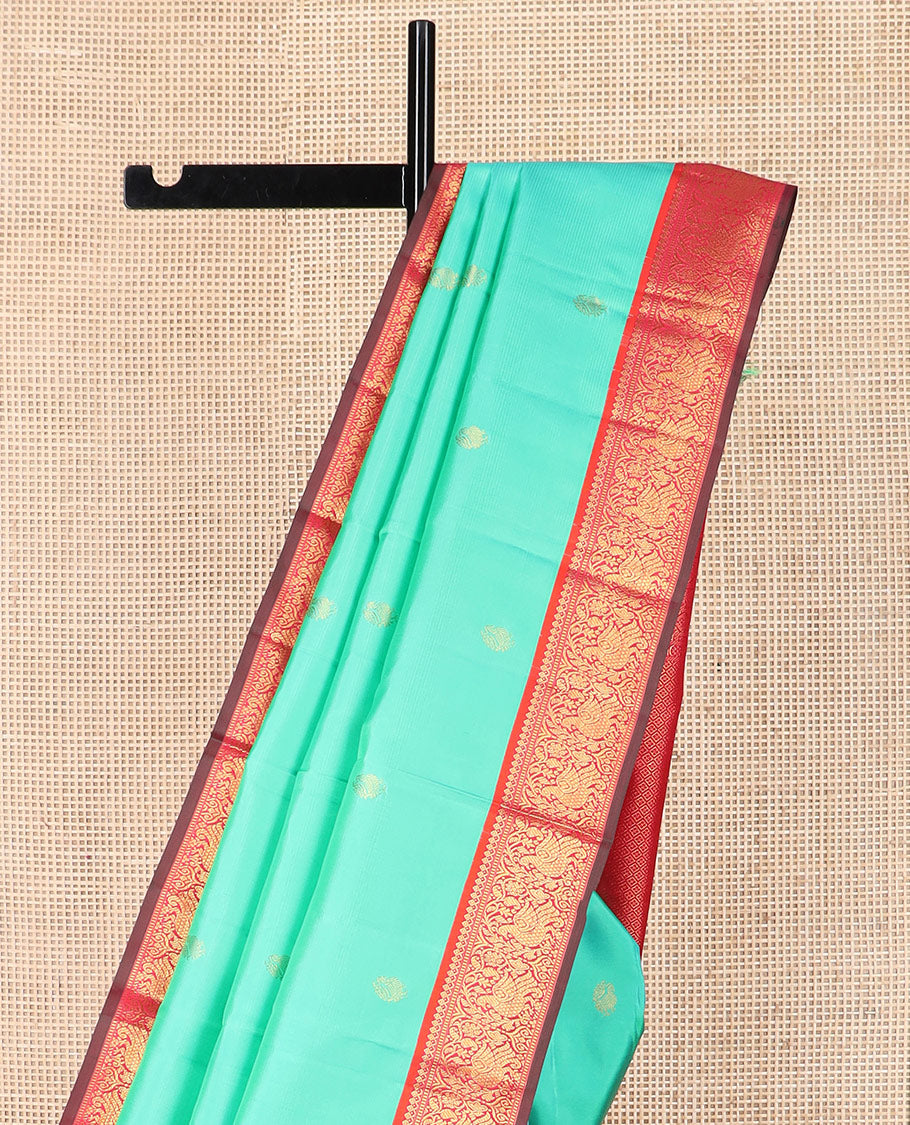 Turquoise mayil buttas silk saree, contrast border of thilakam mokku, muthu, and mayil designs, and jaal pallu