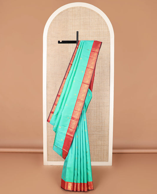 Turquoise mayil buttas silk saree, contrast border of thilakam mokku, muthu, and mayil designs, and jaal pallu
