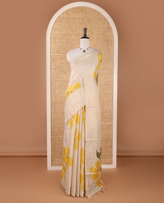 Borderless cream printed onam tissue silk saree features yellow color five-petal flower & leaf motifs print, matching floral print blouse
