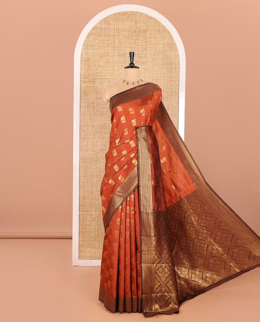 Rust Orange Kanchi Silk Saree Graced with Gold Zari Buttas Woven All Over Its Body, Complemented by Contrast Traditional Zari Design Border, Pallu Majestically Detailed with Intricate Zari Designs, and Paired with a Contrast Blouse