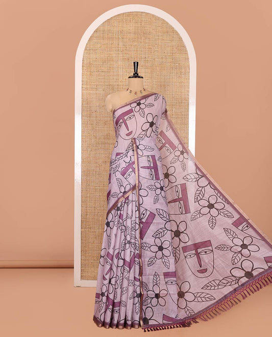 Light Purple Linen Cotton Saree, Featuring Flowers and Faces Printed on Its Body, Subtle Zari Piping Border, Pallu Mirrors the Self-Print, and Comes with a Contrast Blouse