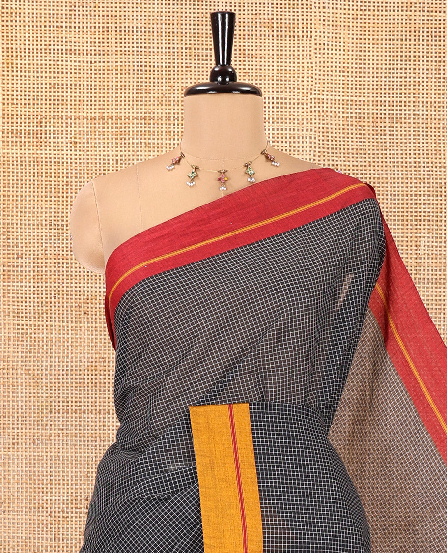 Black and Mustard-Red Chettinad Cotton Saree, Subtly Sparkled with Checked Design on Its Body, Complemented by Contrast Ganga-Jamuna Border, Striped Pallu, and Comes Without a Blouse