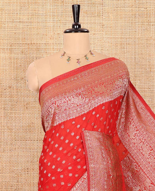 Red Semi-Banaras Khaddi Georgette, Delicately Detailed with Zari Buttas All Over Its Body,  Subtly Sparkled Traditional Border of Rudraksham, Elephant, and Floral Vine Designs, Pallu of a Herd of Elephants, and Paired with a Matching Blouse