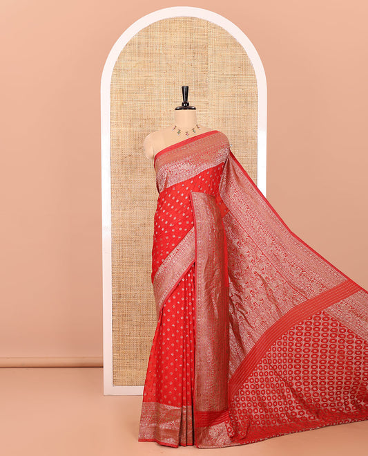 Red Semi-Banaras Khaddi Georgette, Delicately Detailed with Zari Buttas All Over Its Body,  Subtly Sparkled Traditional Border of Rudraksham, Elephant, and Floral Vine Designs, Pallu of a Herd of Elephants, and Paired with a Matching Blouse
