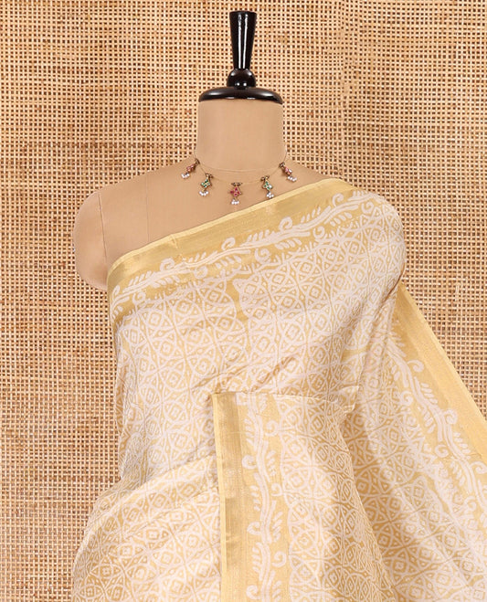 Gold geometric batik printed banana pith saree, printed piping border, paisley motifs steeped pallu, and a matching blouse