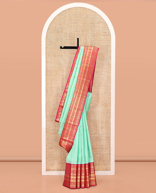 Turquoise Vasundhara Silk Saree, Embellished with Zari Buttas All Over Its Body, Complemented by a Contrast Border of Thilakam Mokku, Yaanai, Iruthalai Pakshi, and Kodi Visiry Designs, Grand Pallu, and Paired with a Contrast Blouse