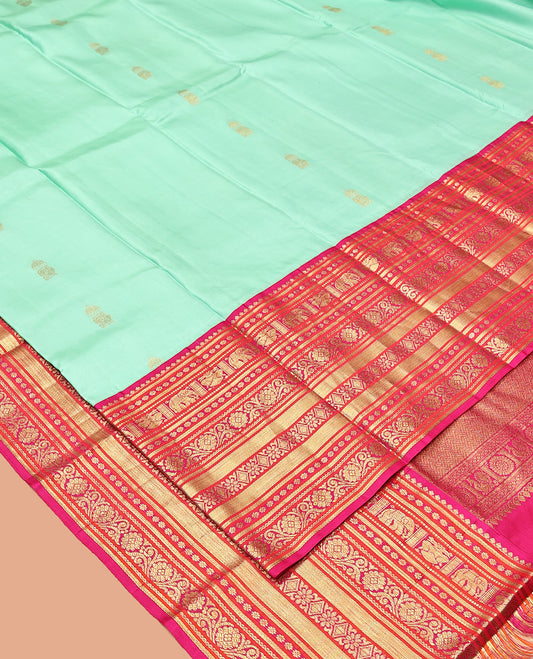 Turquoise Vasundhara Silk Saree, Embellished with Zari Buttas All Over Its Body, Complemented by a Contrast Border of Thilakam Mokku, Yaanai, Iruthalai Pakshi, and Kodi Visiry Designs, Grand Pallu, and Paired with a Contrast Blouse