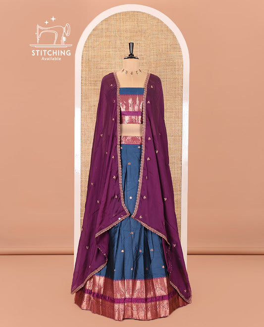 Blue and Purple Semi-Banarasi Half-Saree Featuring Zari Buttas Skirt, Complemented by Contrast Rettai Pettu, Traditional Border of Floral Creeper Designs, Paired with a Matching Blouse, and a Satin Georgette Embroidered Scallop Dhavani
