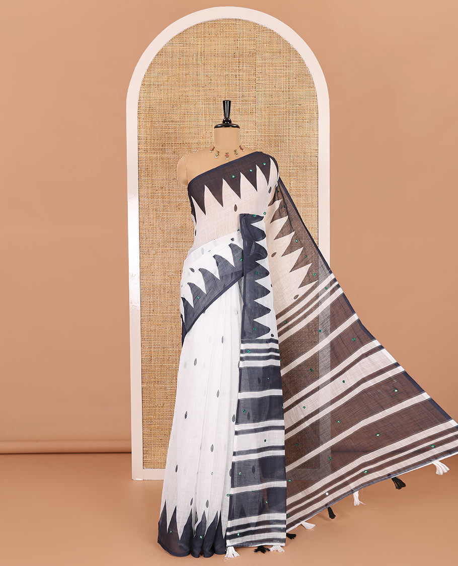 White thilakam buttas and mirror work khadi mul cotton saree, contrast temple border, striped and buttas pallu, and a contrast printed blouse