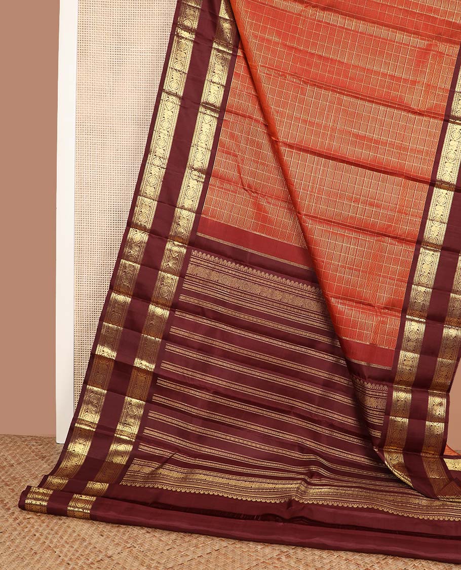 Orange zari checked Kanchipuram silk saree, contrast rettai pettu border of rekku, banaras, neli, and mayil chakram designs, and pallu of lavangam designs